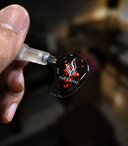 INFERNO 6-driver hybrid IEM held in hand, red and black flame faceplate, handcrafted in Taiwan by NOWA Acoustics